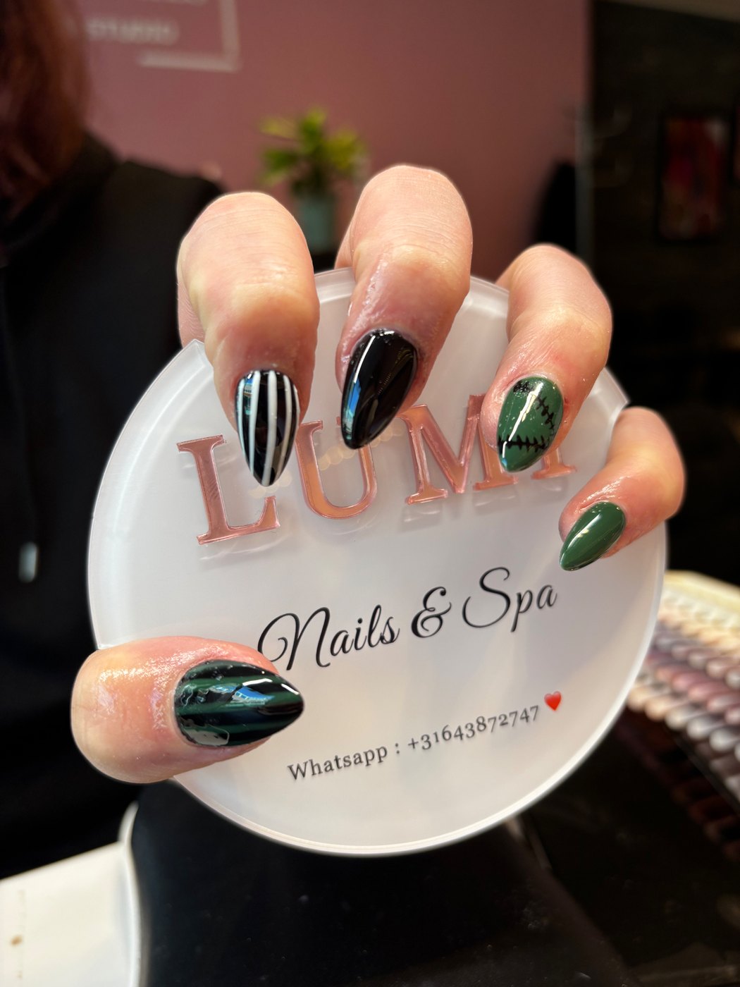 Zwart-groene nagels met strepen en stitch nail art
