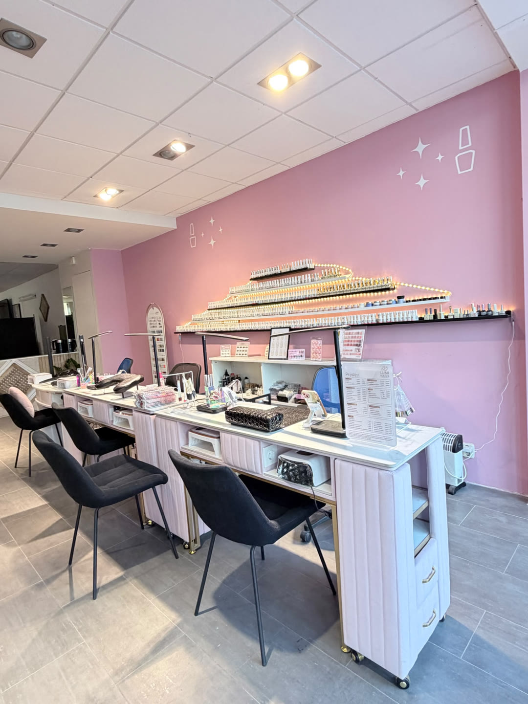 Manicuretafels met nagellampen en stoelen in de studio